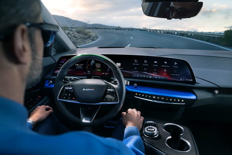 Front View of the 2026 OPTIQ-V Driving Through the Dusk Utilizing its Headlights | Orr Cadillac Fort Smith in Fort Smith AR